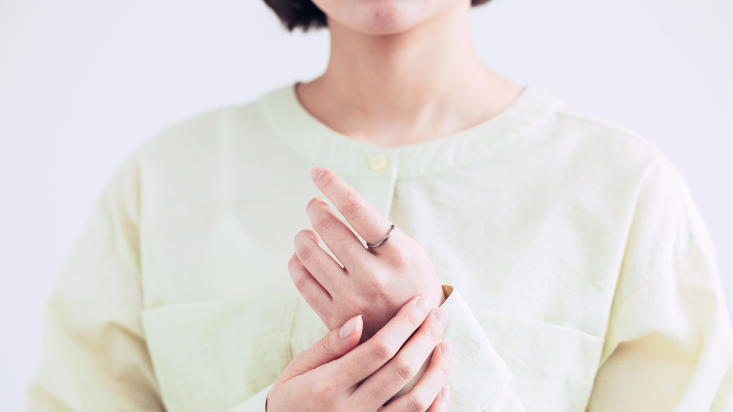 左の人差し指に指輪をしている女性の写真